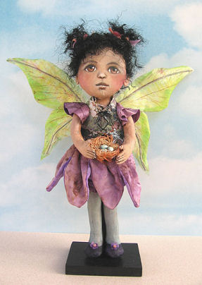 wings of this pretty 12” fairy wearing a tapestry vest over a petal skirt are painted silk.